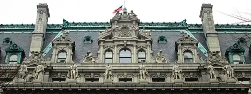 Photograph showing the elaborate details of the mansard roof, with carved statues in front