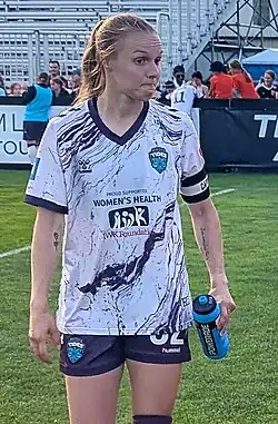 Player in uniform walking and looking to her left