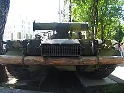 Rear view of T-80 tank on museum display, with large wooden beam stowed to undercarriage