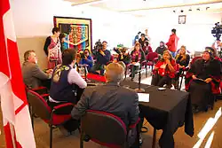 Press conference on Teslin Tlingit Council administration of justice at the Teslin Tlingit Heritage Centre, with council leaders and government officials seated at a table facing media.