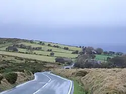 single carriageway road heading downhill through farmland