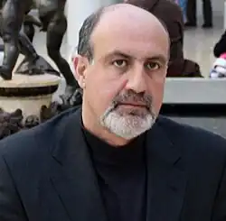 Image of Nassim Nicholas Taleb from the shoulders up. He has receding hair and a short mostly white beard.