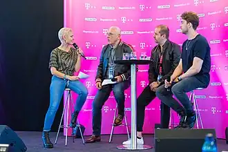Marek Lieberberg answers a host's questions during an interview with two men sitting next to them