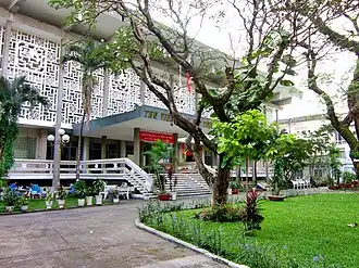 A white modernist building surrounded by trees