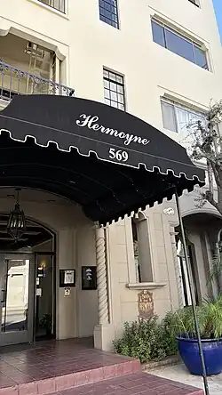 A black awning in front of an apartment building that says "Hermoyne" and "569".