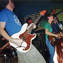 The Wicked Farleys performing live around 1999โ2000. From left to right: Ken Bernard (obscured), Michael Cory, Vanessa Downing, Michael Brodeur
