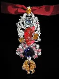 Detailed view of the recreated great Golden Fleece of king Louis XV of France. Below the 107 carats (21.4&nbsp;g; 0.75&nbsp;oz) spinel Côte de Bretagne hangs the French Blue diamond and the fleece itself, set with hundreds of yellow diamond replicas.