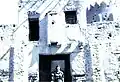 A woman stands before an Ottoman-era Turkish fort, Qatif, 1950