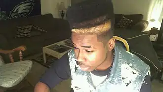 Image 121American teenager with hi-top fade and distressed acid wash denim vest, 2010, showing early 2010s retro revival trends. (from 2010s in fashion)
