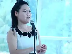 Young Asian woman speaking at a microphone