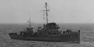 A small ship (Dione) faces to the right of the camera, which has taken the photo at a bit of an angle. The deck of Dione is packed with people.