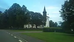 Photograph of a church next to a road and green grass