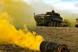 Smoke billowing from a yellow M18 with Polish forces in the background, Afghanistan, February 23, 2010.