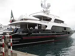 Rear view of a black-and-white yacht docked at a harbour