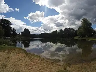 A photo of Valgjärv showing the lake reflecting white clouds overhead