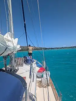 Man at the bow of a Valiant 40 sailboat near Fiji