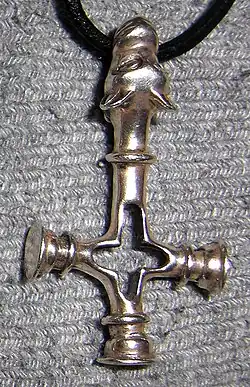 Replica of a silver pendant from the Viking period (c. 11th century) found in Foss, Iceland, sometimes described as "wolf cross" (vargkors). It could be interpreted both as a Christian cross and as a Heathen Thor's hammer (Mjolnir or Mjöllnir).