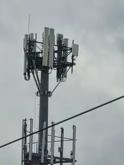 Close-up of antennas and radio units on a monopole tower.