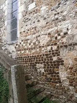 Color photograph of a wall with small rubble stones of different colors.