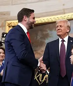 Photograph of JD Vance and Donald Trump shaking hands and smiling.