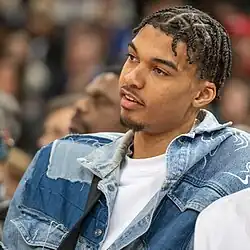 Wembanyama watching a NBA game from off the court.