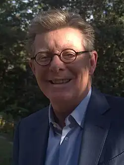 Headshot of Price in a forest, illuminated by the sun