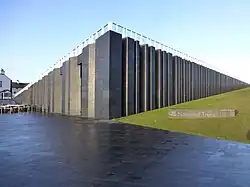 Image of the exterior of a large building made of stone pillars.