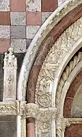 Medallions from left superior frieze of portal, depicting showing mercy by charity to the jailed, and by burying the dead; St George slaying the Dragon flanks the portal