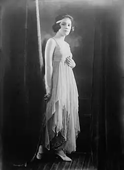 A young white woman standing in a sequined gown