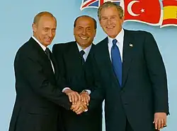 Putin with Italian prime minister Silvio Berlusconi and U.S. president George W. Bush at the NATO-Russia Council meeting in Rome on 28 May 2002[313]