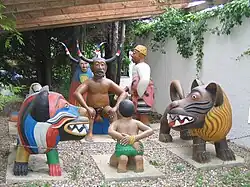 Cyprien Tokoudagba, Voodoo Pantheon (1989). Zangbeto (with horns, background) and Legba, sitting naked, judging a sinner.
