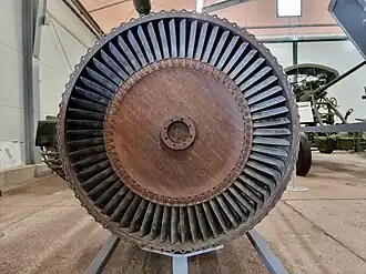 This rear view of a Klimov VK-1 turbojet shows the parts responsible for turbine temperature overshoot after increasing thrust from idle to take-off, known as transient EGT overshoot.[123] Visible is the turbine blade tip clearance which is a leakage path for gas which doesn't contribute to the power developed by the turbine. Increased gap, and leakage, means more fuel, indicated by a higher EGT, is required to get take-off thrust. Clearance is increased temporarily every time the engine goes from idle to take-off because the light casing expands quickly to the turbine gas temperature but the heavy turbine rotor takes minutes to expand to its hot diameter.