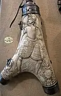French, c. 1590, antler and steel. The figure carries a gun and a flask on his belt