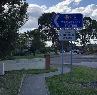 An area of Warabrook showing a sign for the estate and towards the train station