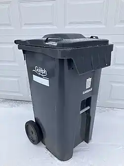 A residential garbage bin with wheels in Guelph, Ontario, Canada