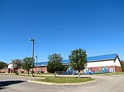 Brick building with a blue roof and a playground in front