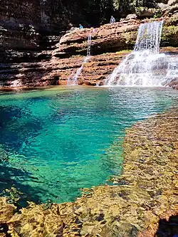 Tiered plunge pool waterfall surrounded by green cliffs