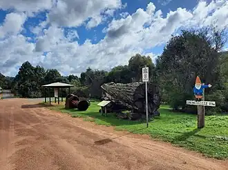 Wellington Mill tourist bay, with Jarrah log, saw and directions to Gnomesville