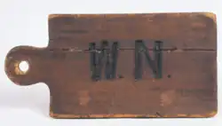 Wooden plaque with "W.N." engraved in.