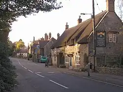 Street scene with buildings on the right including a pub with sign The Castle.