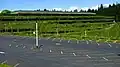 View of the Weyerhaeuser headquarters showing a parking lot in the foreground and the cascadign plants over its facade.