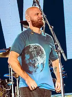 Champion walking on stage while tidying up his blue shirt with a moon print