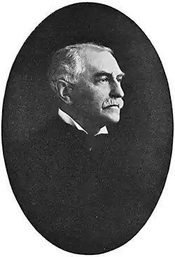 Black and white photograph of William Jewett Tucker with a mustache, wearing a suit and high-collared shirt.