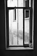 Window of occupied building, with a Guy Fawkes mask placed next to it. Guy Fawkes masks have often been used as a symbol of resistance in the Occupy movement.