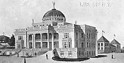 Photograph of a domed Palladian-style, four-story building with statuary on the roof and a columned portico.
