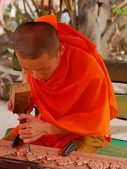 Image 15Monk woodworking temple details (from Culture of Laos)