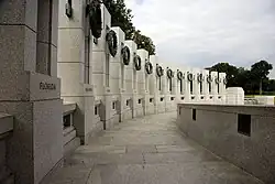 Aerial view of oval-shaped memorial with pond and white walkways
