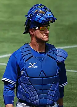 Yan Gomes looking to his left wearing sunglasses and a blue Toronto Blue Jays uniform and catchers gear
