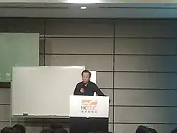 Yi giving a talk at the Hong Kong Convention and Exhibition Centre in July 2013