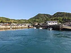 A photo showing the sea and a view of the village of Yugeshima.